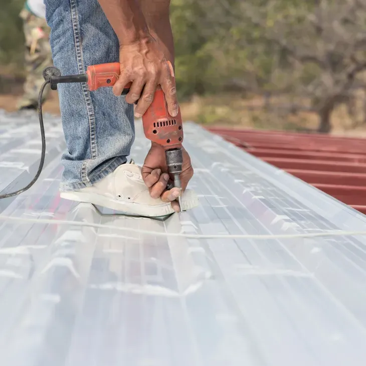 A worker installs roofing.